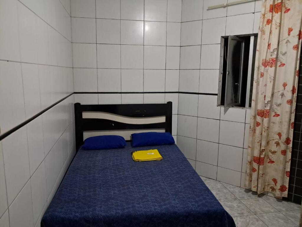 a small room with a blue bed with a yellow tray on it at Hotel pousada sonho meu in Arapiraca