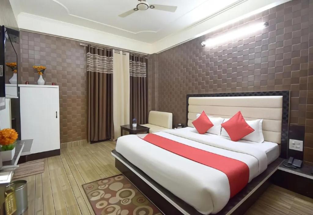 ブバネーシュワルにあるGoroomgo Om Sai Residency Bhubaneswarのベッドルーム1室(大型ベッド1台、赤い枕付)
