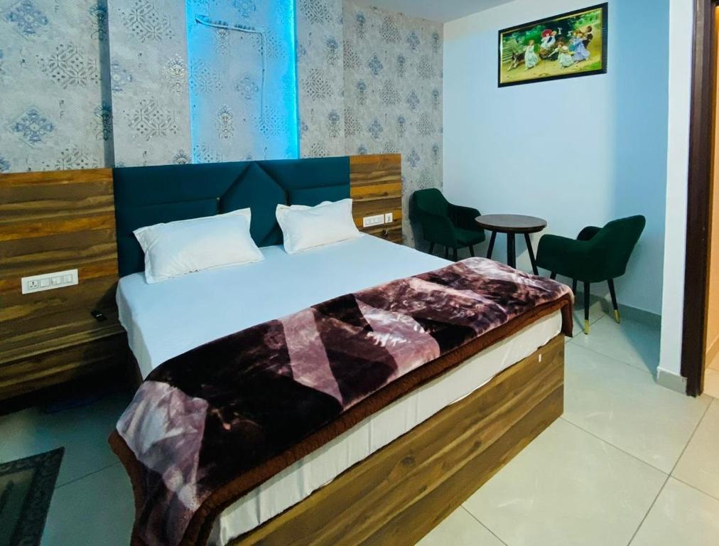 um quarto com uma cama, uma mesa e cadeiras em Hotel Azaara em Patiala
