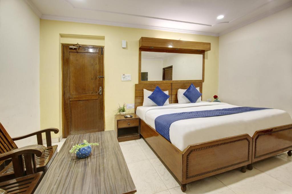 ein Schlafzimmer mit einem großen Bett und einem Tisch in der Unterkunft Hotel The Eden Park in Noida