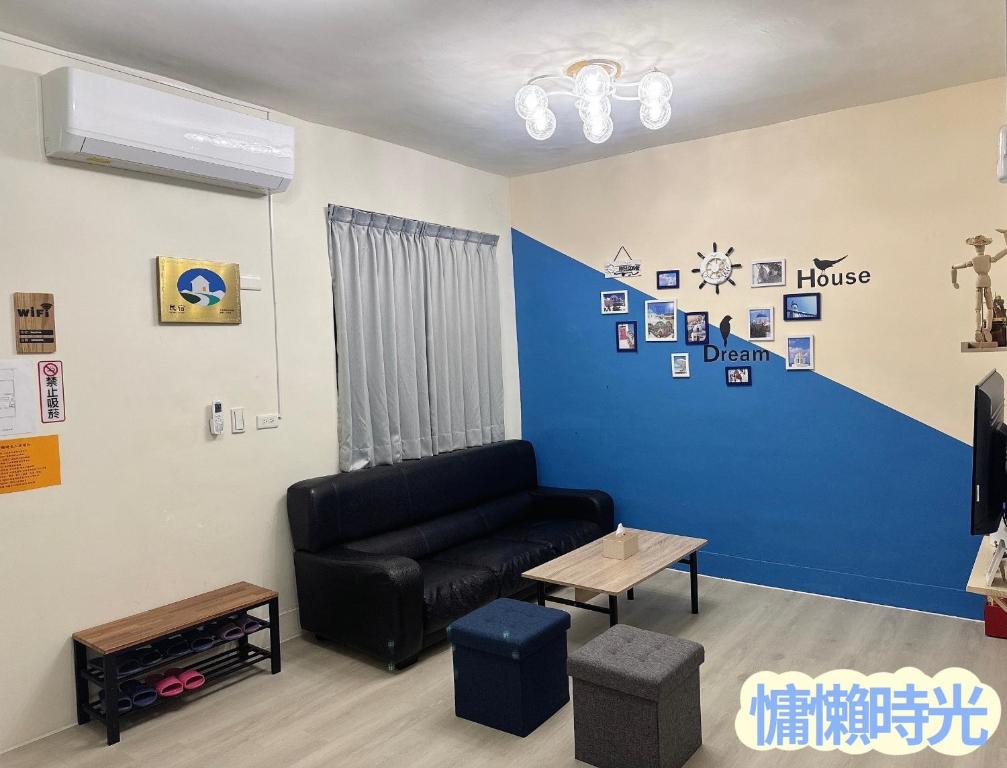 sala de estar con sofá y pared azul en Lazy Time B&B, en Miaoli