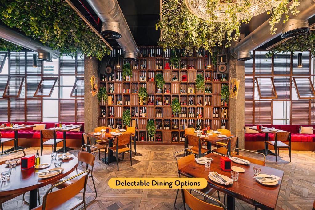 a restaurant with tables and chairs and a wall of books at TRYP by Wyndham Dubai in Dubai