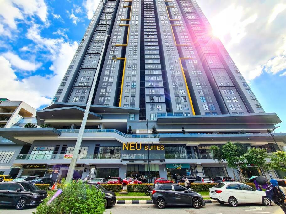 un edificio alto con macchine parcheggiate di fronte di Neu Suites Studio Room - 3km to KLCC, 8 mins walk to LRT a Kuala Lumpur