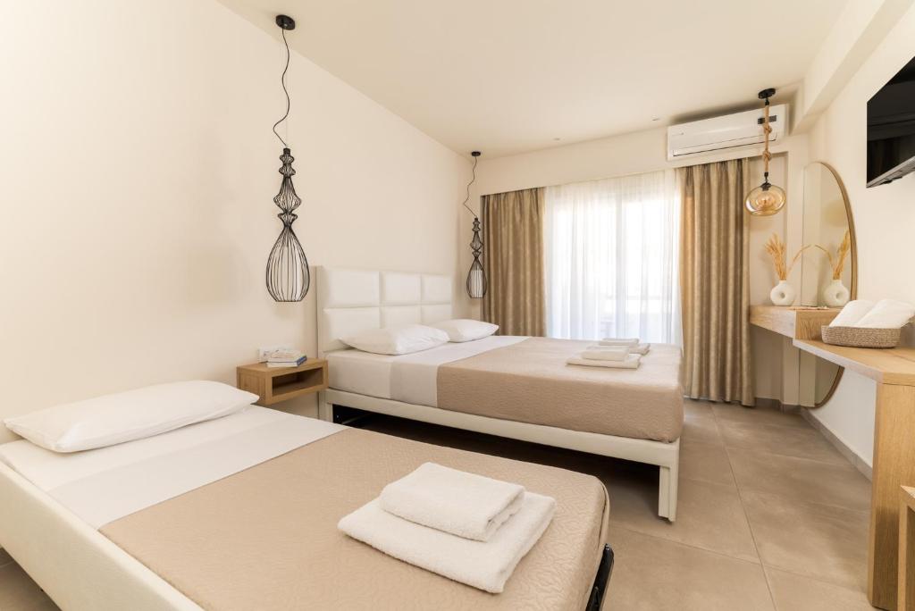 um quarto de hotel com duas camas e uma cozinha em Mystery Suites and Apartments em Neoi Poroi
