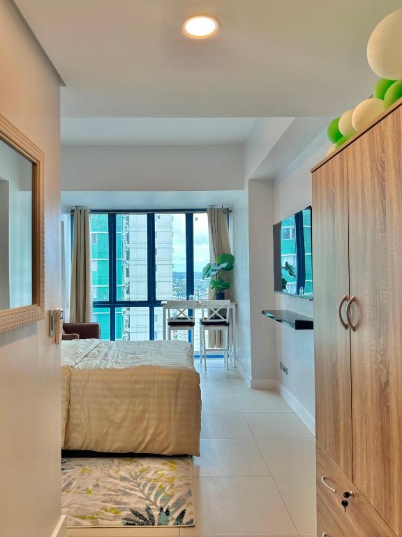 1 dormitorio con 1 cama y comedor con vistas en 38 Park Avenue Condominiums, en Cebú