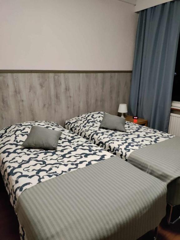Dos camas una al lado de la otra en un dormitorio. en Hotel Ackas, en Toijala