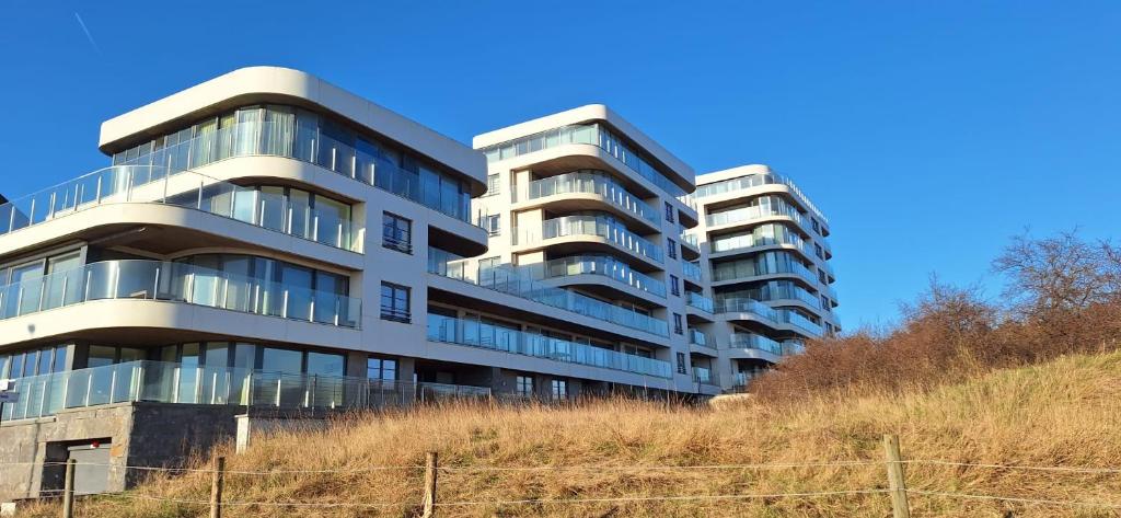 een hoog gebouw met glazen ramen op een heuvel bij North beach in Oostende