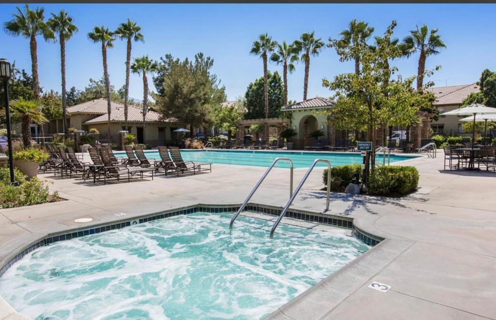 a swimming pool in a resort with palm trees at The Plaisir - Pool & Spa in Santa Clarita