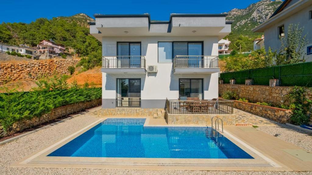 uma villa com piscina em frente a uma casa em Villa Lotus Yeşilüzümlü em Fethiye