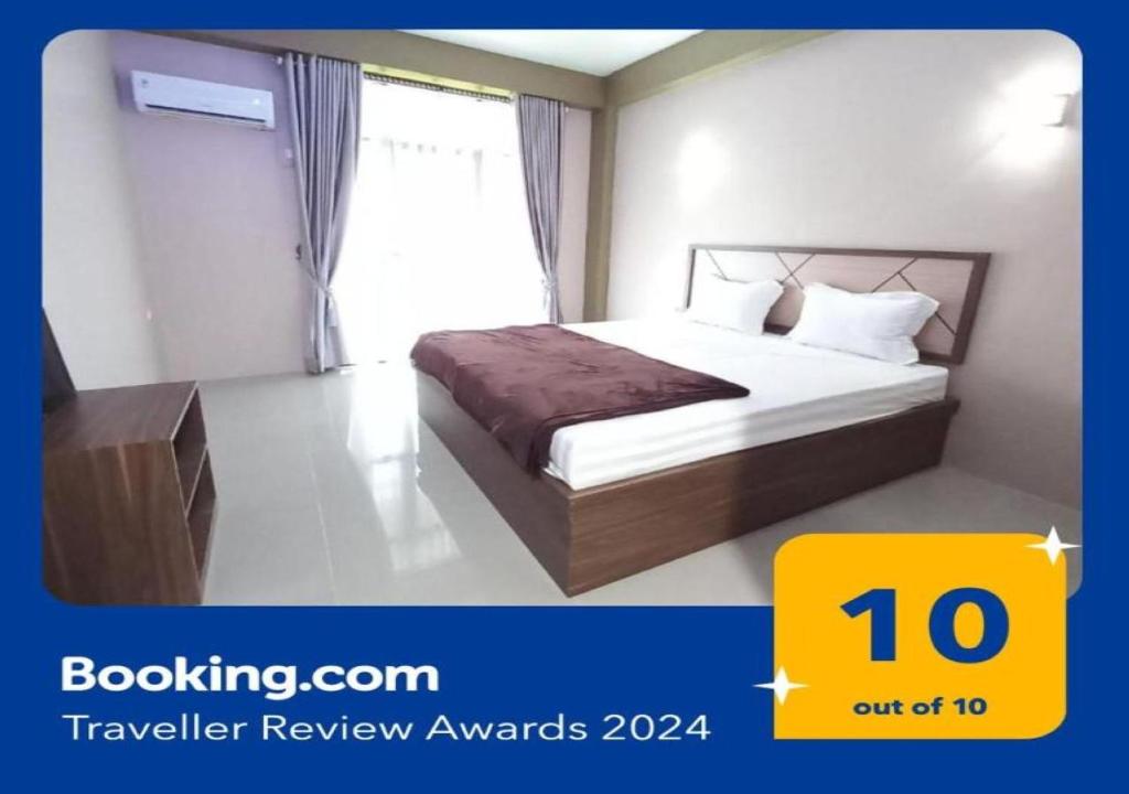 a hotel room with a bed and a window at OYO 92928 Lavina Guesthouse in Dumai