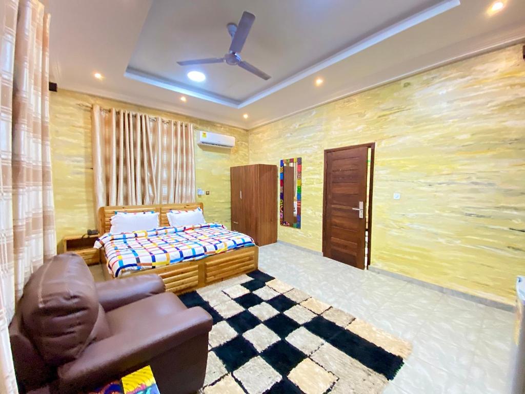um quarto com uma cama e uma cadeira em Bays Boutique Apartment em Accra