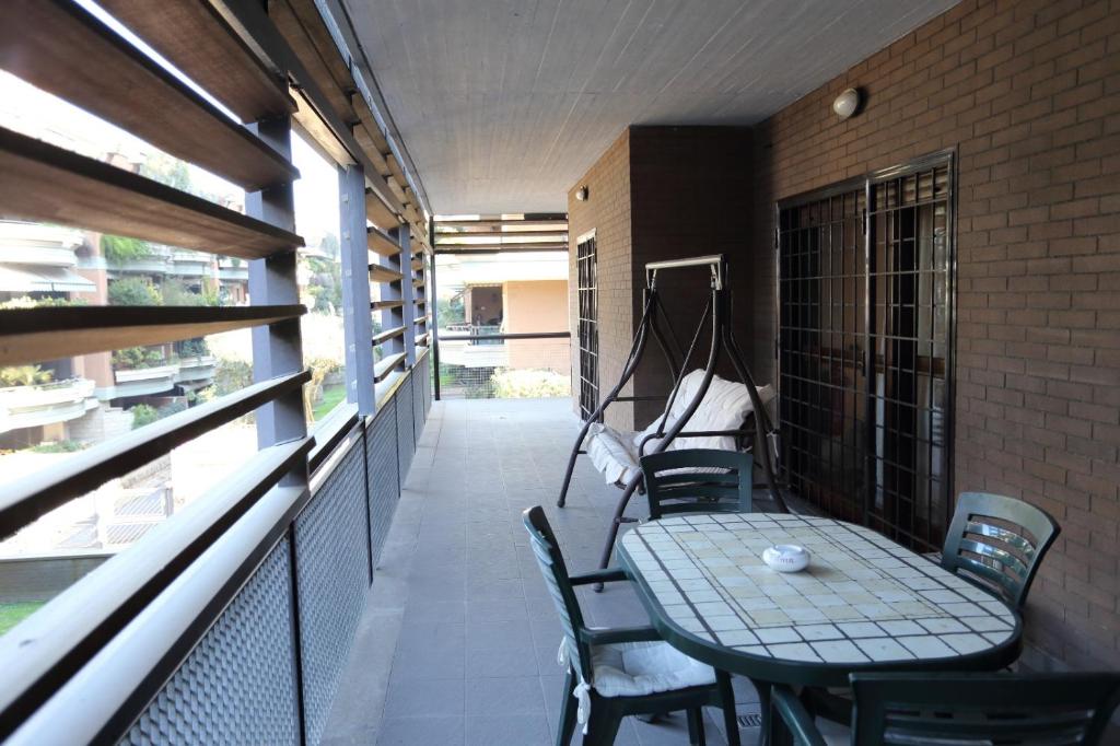 patio con mesa y sillas en el balcón en Home Sorbara "Luxury Home", en Roma