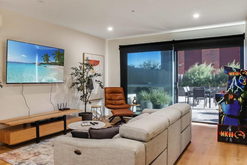 - un salon avec un canapé et une télévision murale dans l'établissement Retreat on Bellerine I Corporate or Getaway, à Geelong