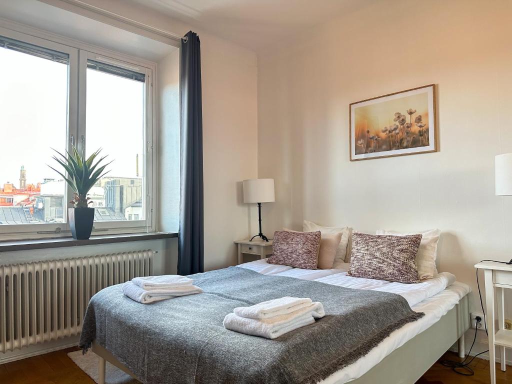 a bedroom with a bed with two towels on it at Stay Inn Apartment Sveavägen in Stockholm