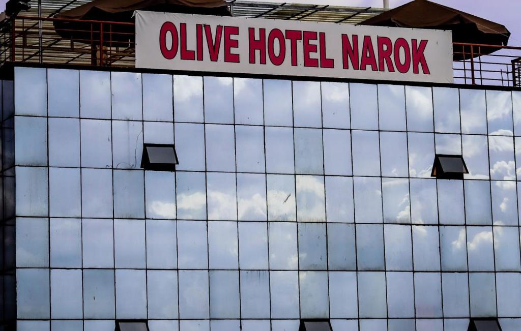 Olive Hotel Narok في Narok: علامة مكتوب عليها فندق زيتون كاررو على مبنى