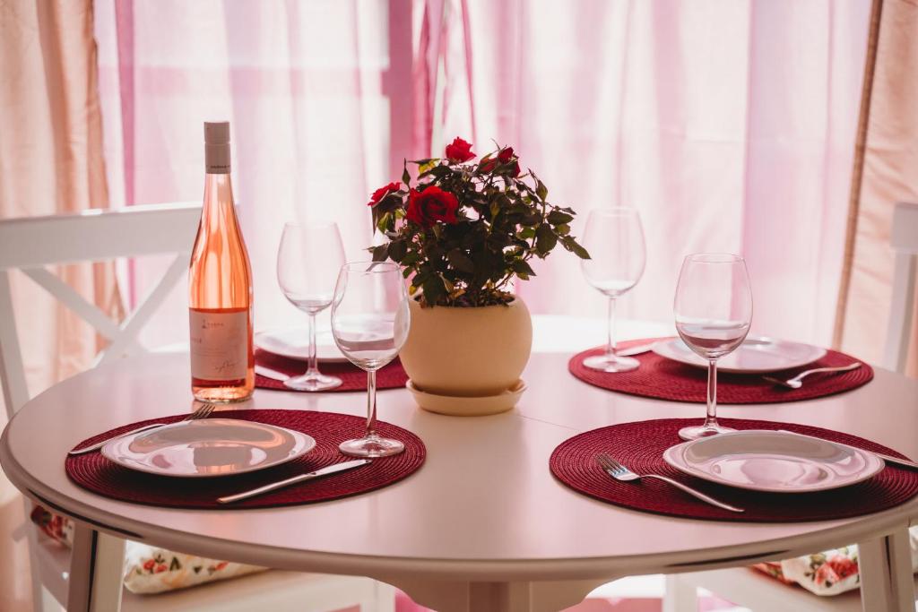 a table with two plates and a bottle of wine at Andreya's Sea apartment-Beach, Sea garden ,Old Town, Free Parking, Free EVcharging Station in Varna City