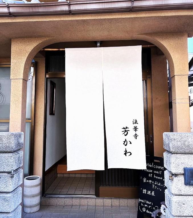 una entrada a un edificio con un cartel en él en Guesthouse法華寺Yoshikawa, en Nara