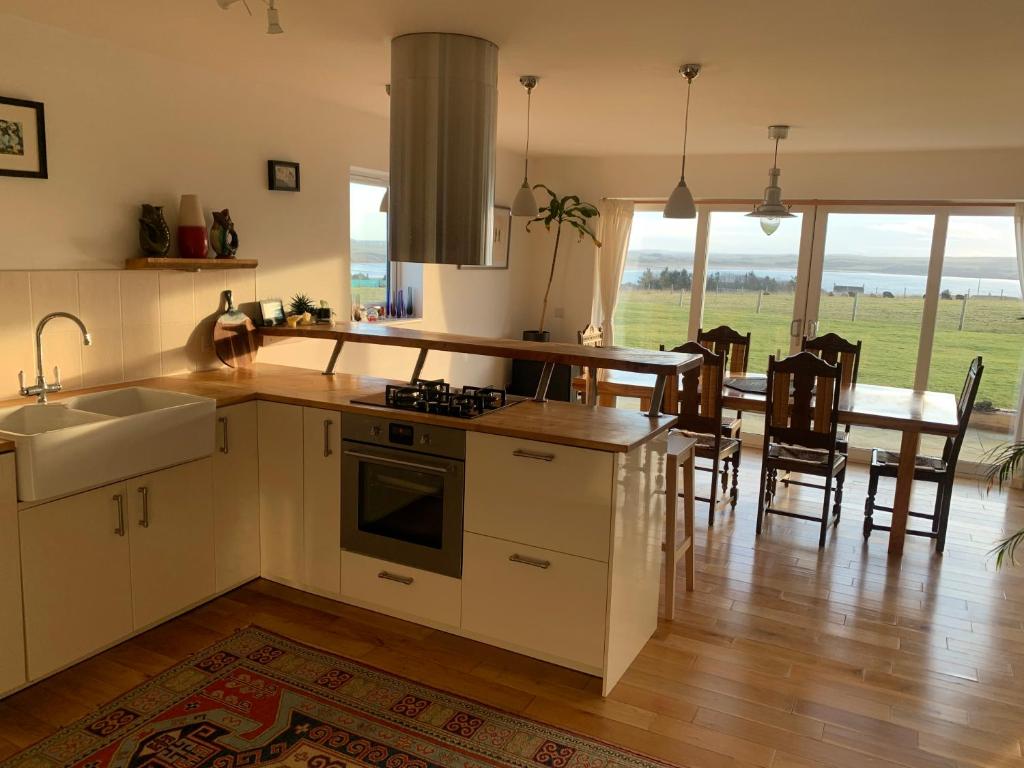 a kitchen and dining room with a table and chairs at Stroma, Dunnet, spacious holiday house with sauna. in Brough