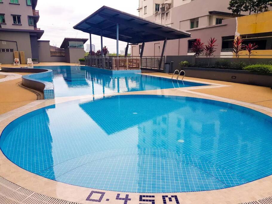 - une grande piscine d'eau bleue dans un bâtiment dans l'établissement Homestay @ Subang Jaya KTM & LRT + High Speed INET, à Subang Jaya