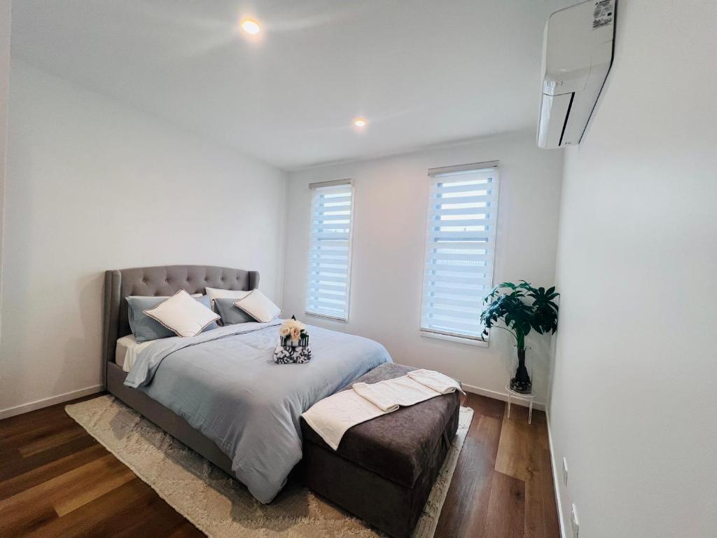 a bedroom with a large bed and two windows at Double storey, Walk to Showground in Melbourne