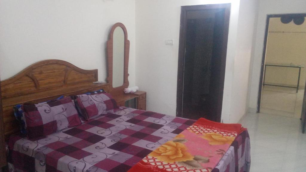 a bedroom with a bed with a quilt on it at SPALON Holiday Home in Hyderabad
