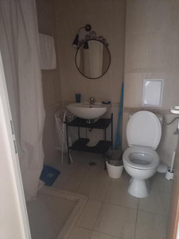 a bathroom with a white toilet and a sink at Апарт-хотел ПОМОРИЕ РЕЗИДЕНС in Pomorie