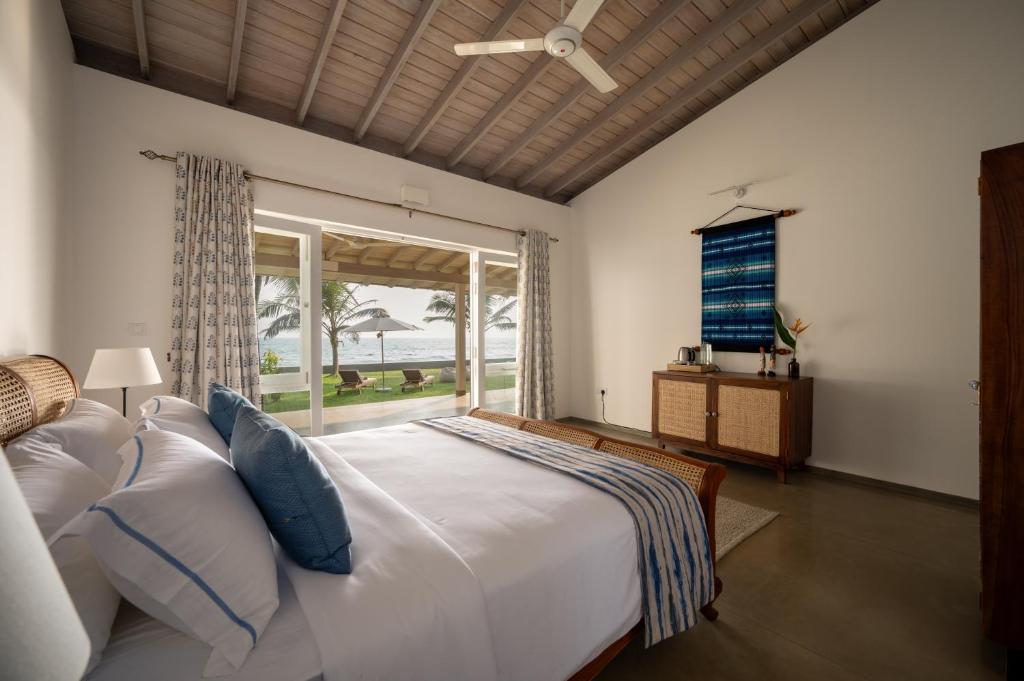 a bedroom with a large bed with a large window at Nil Ralla in Talpe