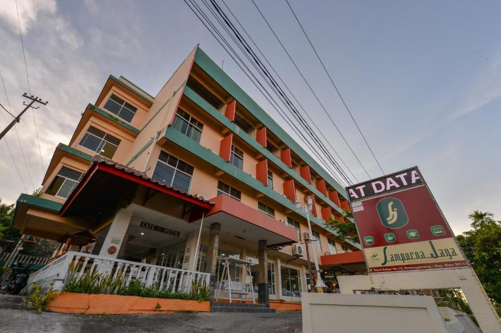 un edificio con una señal delante de él en OYO 2487 Sampurna Jaya Hotel, en Tanjung Pinang