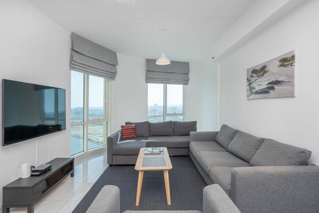 uma sala de estar com um sofá e uma mesa em Budget Friendly Production City em Dubai