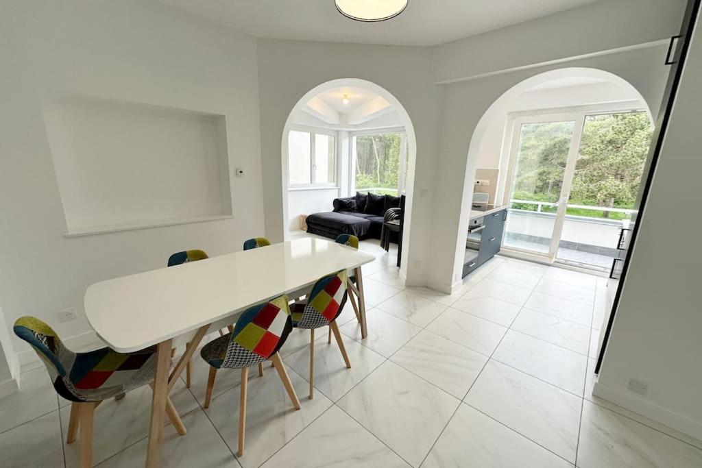 une cuisine et un salon avec une table et des chaises dans l'établissement Appartement avec vue sur la Pinède grande terrasse, à Le Touquet-Paris-Plage