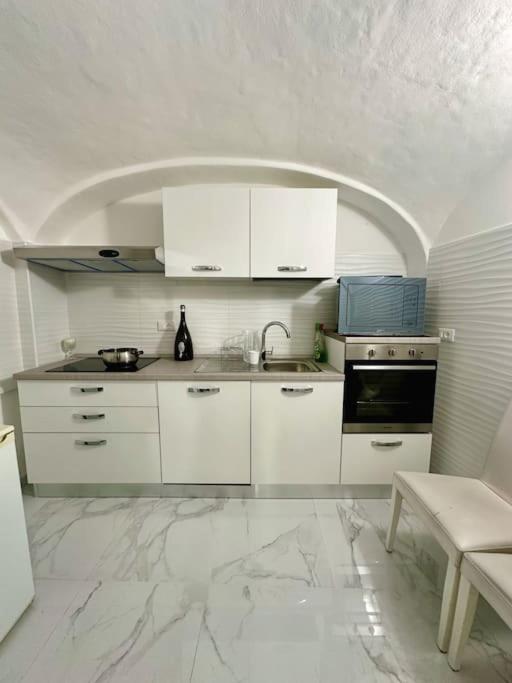 cocina con armarios blancos y suelo de mármol en Luxury House Bergamo vicino aeroporto Orio e Ospedale Papa Giovanni XXIII, en Curno