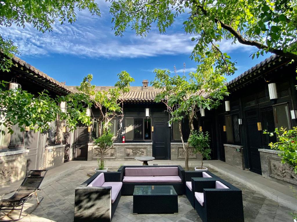 a courtyard with purple benches and a table at Pingyao Elsewhere Gongji Hotel in Pingyao