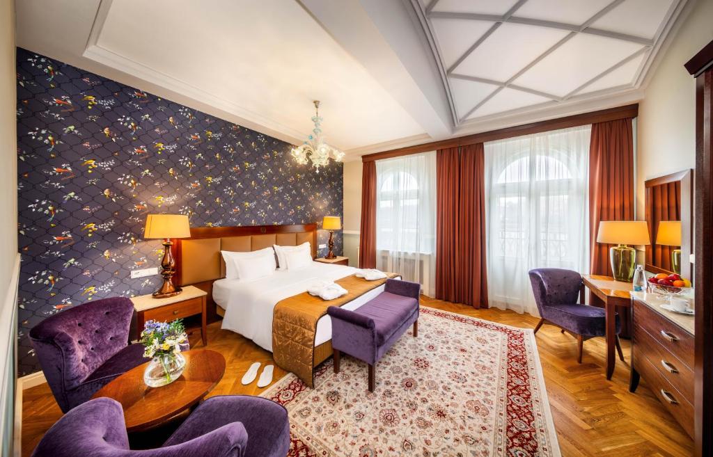 um quarto de hotel com uma cama, uma mesa e cadeiras em Esplanade Hotel Prague em Praga