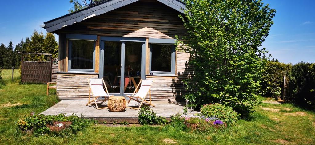 a small cabin with two chairs on a wooden deck at Le Petit Idéal in Leykaul