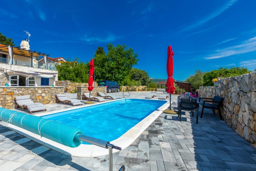 a swimming pool with lounge chairs and umbrellas at Villa 1900 in Kornić