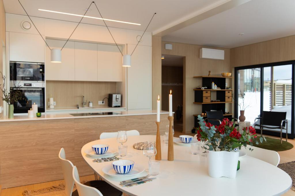 a dining room with a white table and white chairs at Beautiful lodge in Lofoten housing up to 6 guests! in Lyngværet