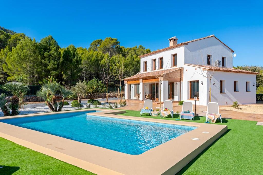 une villa avec une piscine en face d'une maison dans l'établissement Villa Natura - PlusHolidays, à Calp