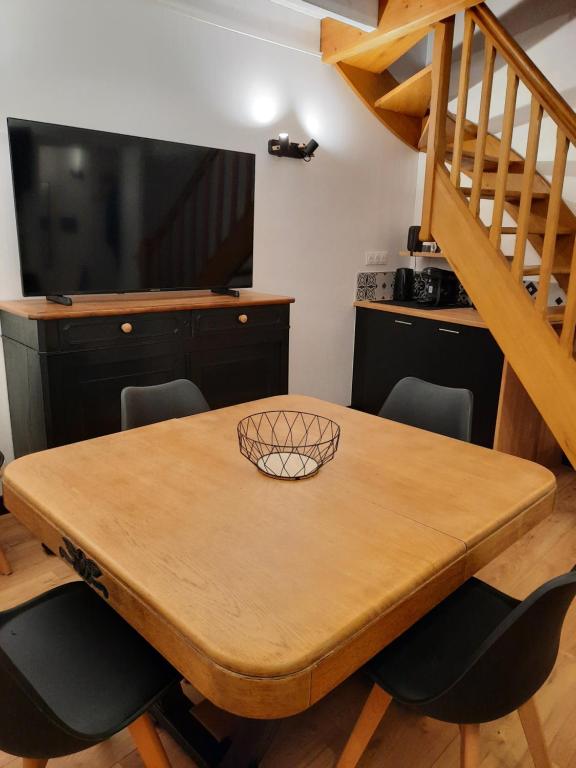 einen Esstisch mit Stühlen und eine Treppe in der Unterkunft maison bonheur in Cerizay