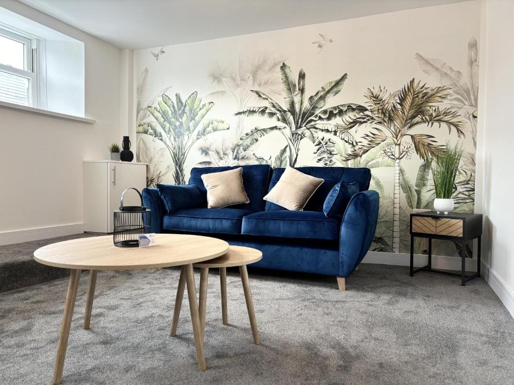 sala de estar con sofá azul y mesa en Hardy Hideaway, en Ulverston
