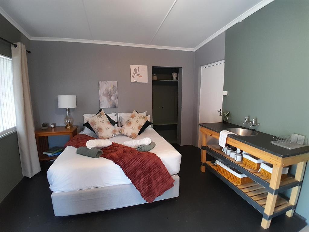 a bedroom with a large bed and a desk at Wilgerboom in Paarl