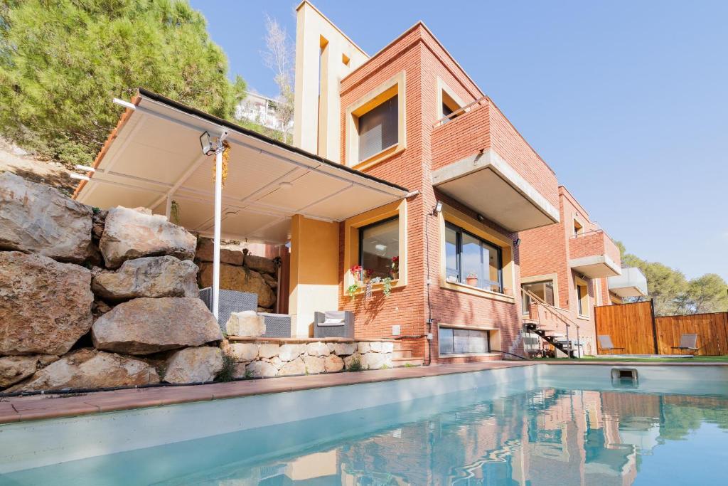 una casa con piscina frente a una casa en Can Camarasa, en Cervelló
