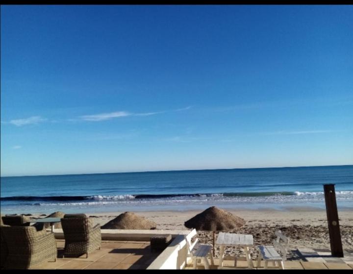 El Maamoura的住宿－H.younes，海滩上设有椅子和遮阳伞,还有大海