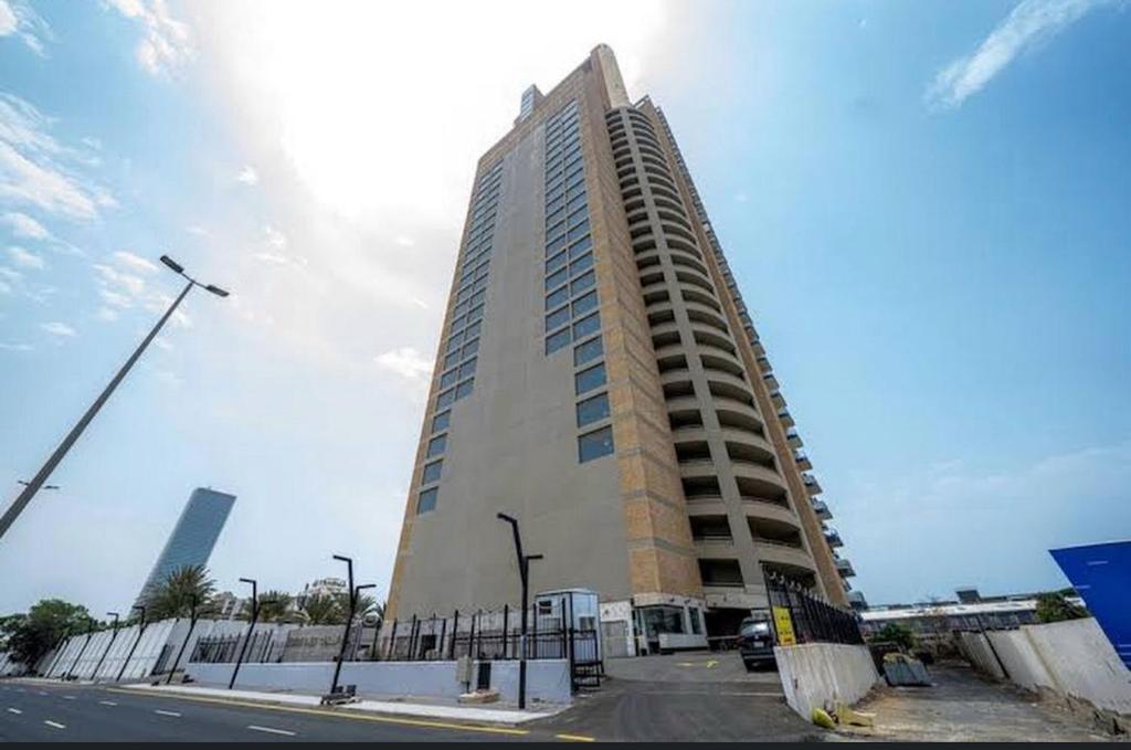 a tall building with a fence in front of it at Almasarat Tower Sea View in Jeddah