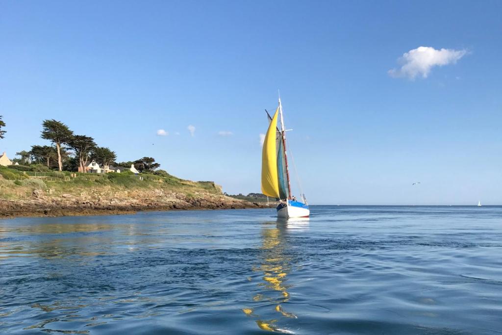 un voilier à voile jaune sur l'eau dans l'établissement Appartement A21, à Arzon