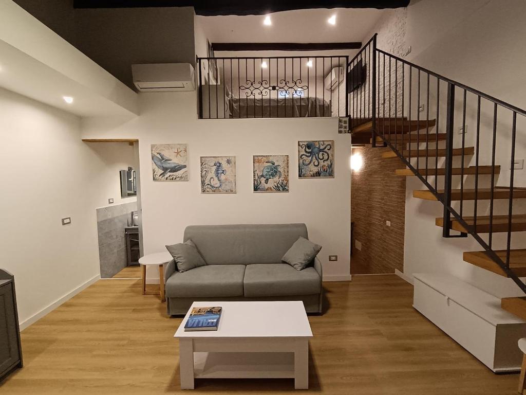 un soggiorno con un divano e una scala di IGIEA APARTMENT a Palermo