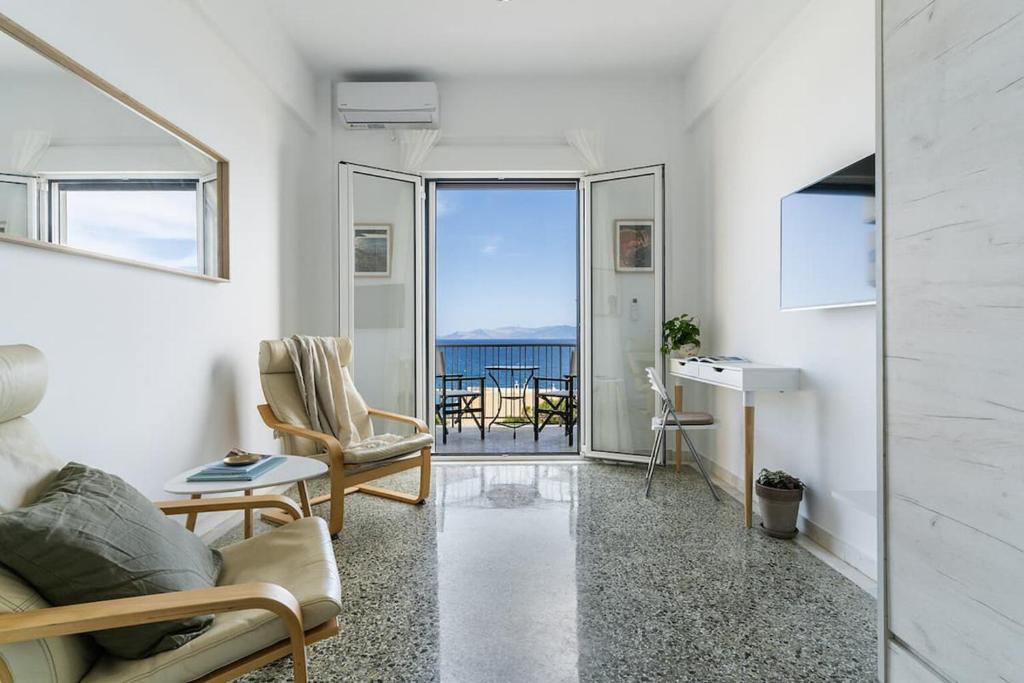 a living room with a view of the ocean at On The Port in Rafina