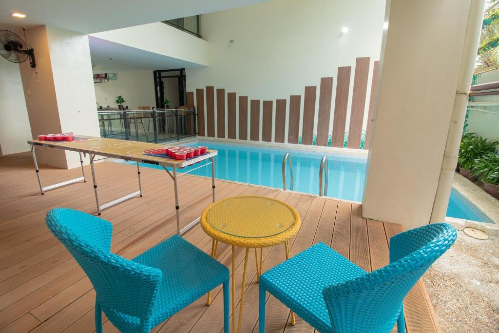 a patio with a table and chairs next to a pool at Bloom Boracay in Boracay