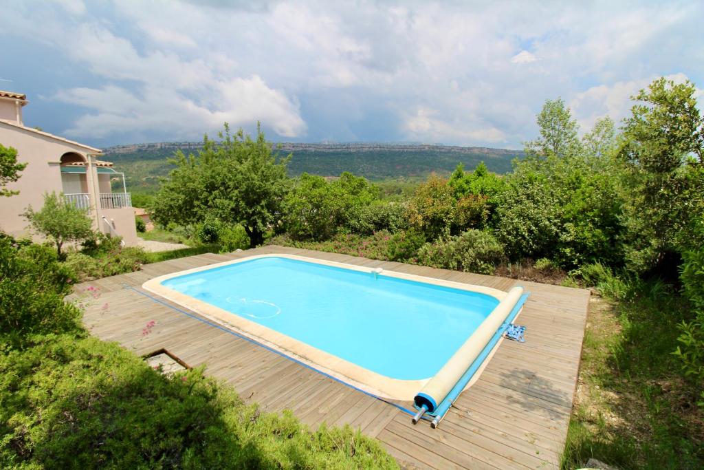 une vue aérienne d'une piscine sur une terrasse en bois dans l'établissement Villa climatisée - 5 chambres - Piscine privée, à Châteauneuf-le-Rouge