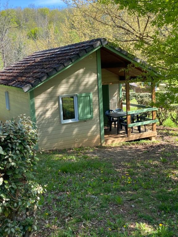 un petit hangar avec une table de pique-nique dans la cour dans l'établissement En toute quiétude, à Lissac-sur-Couze