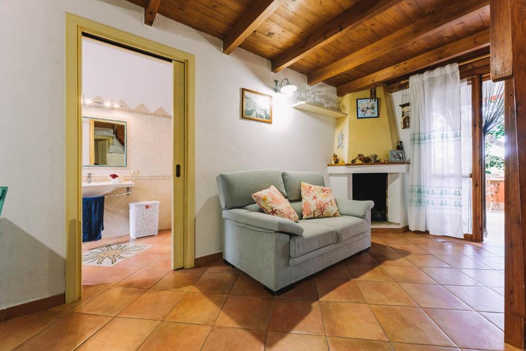 salon z kanapą i kominkiem w obiekcie Oasi del Relax w mieście Costa Rei
